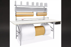 computer desk with two rolls of paper on top of it, part of the Deluxe Packing Table setup